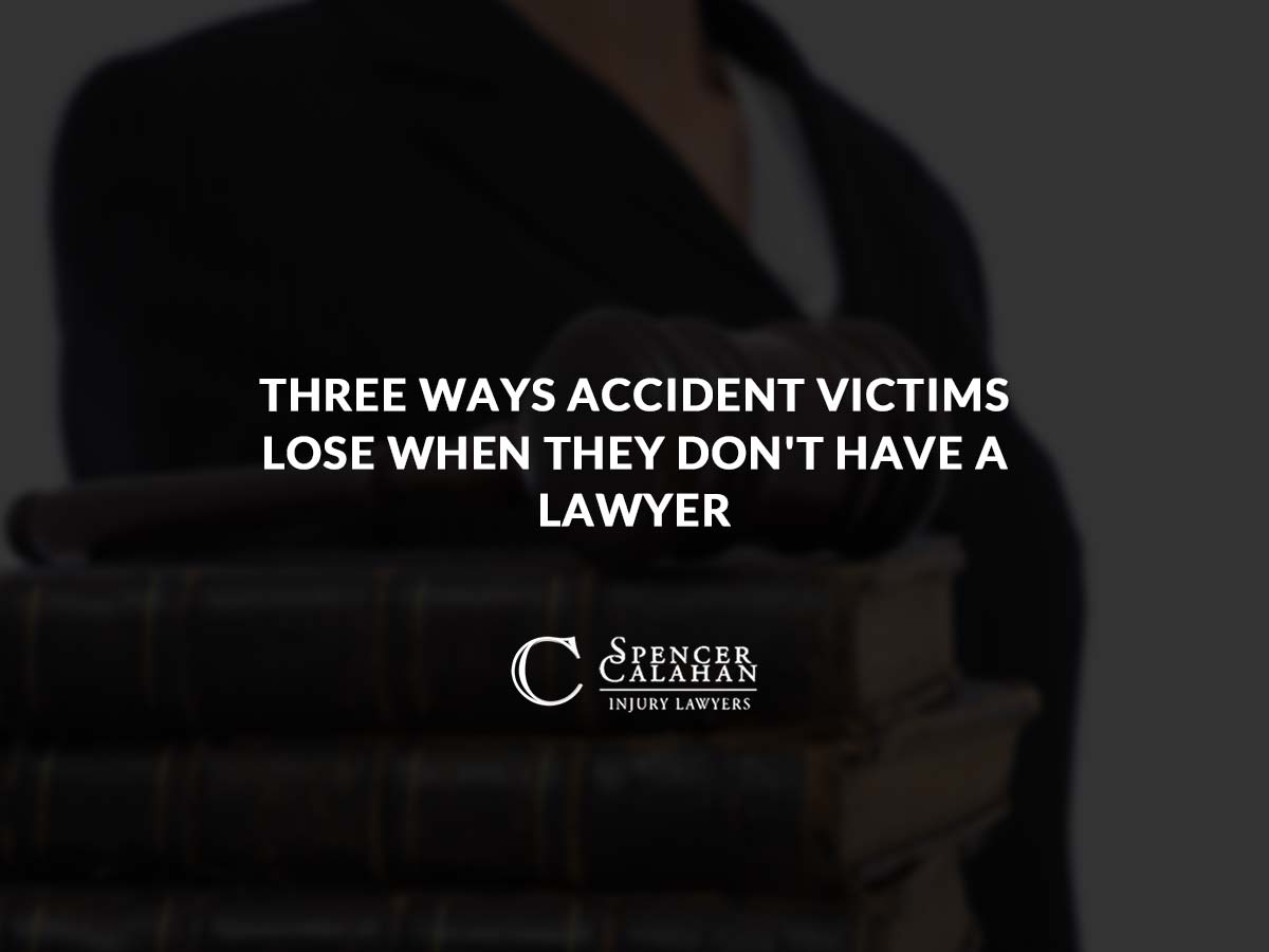 Person standing next stacked books and a gavel. Text overlay: Three Ways Accident Victims Lose When They Don’t Have a Lawyer