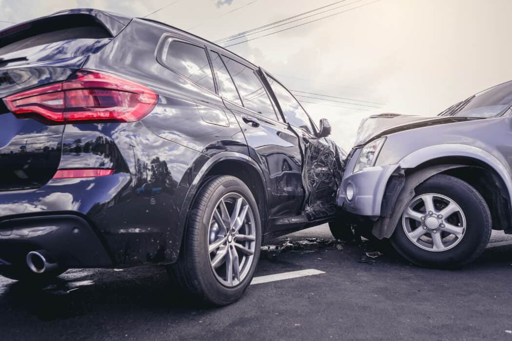 A silver SUV has collided with the side of a black SUV in a road accident requiring the attention of a car accident lawyer.
